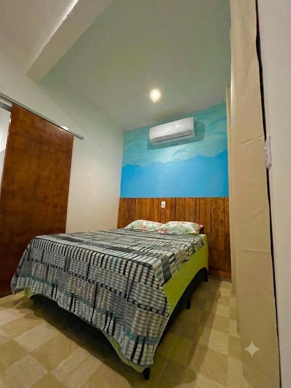 a bedroom with a bed with a painting on the wall at PouCasa Pousada in Araruama