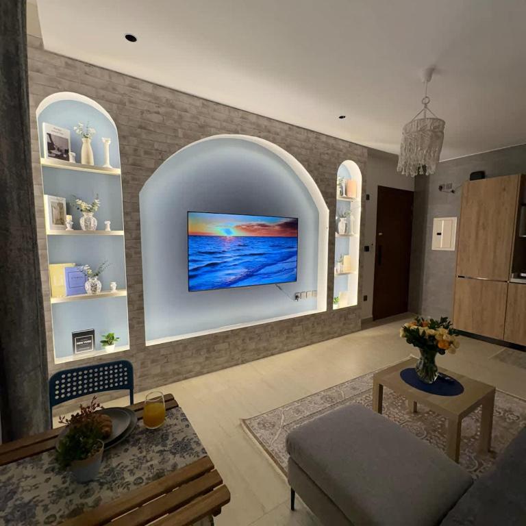 a living room with a tv on a wall at Greek Home4 in Al Khobar