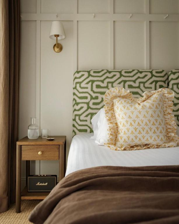 a bedroom with a bed with a pillow and a side table at Domaine Golf Saint-Lazare in Limoges