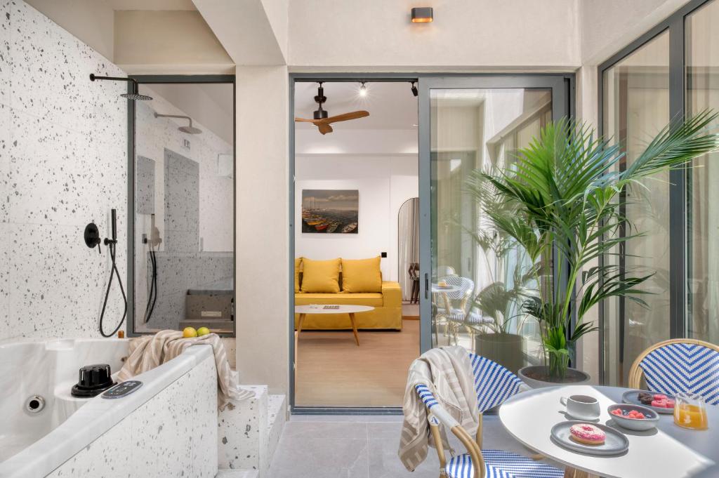 a living room with a tub and a table and chairs at Dock 38 Apartments Collection in Piraeus