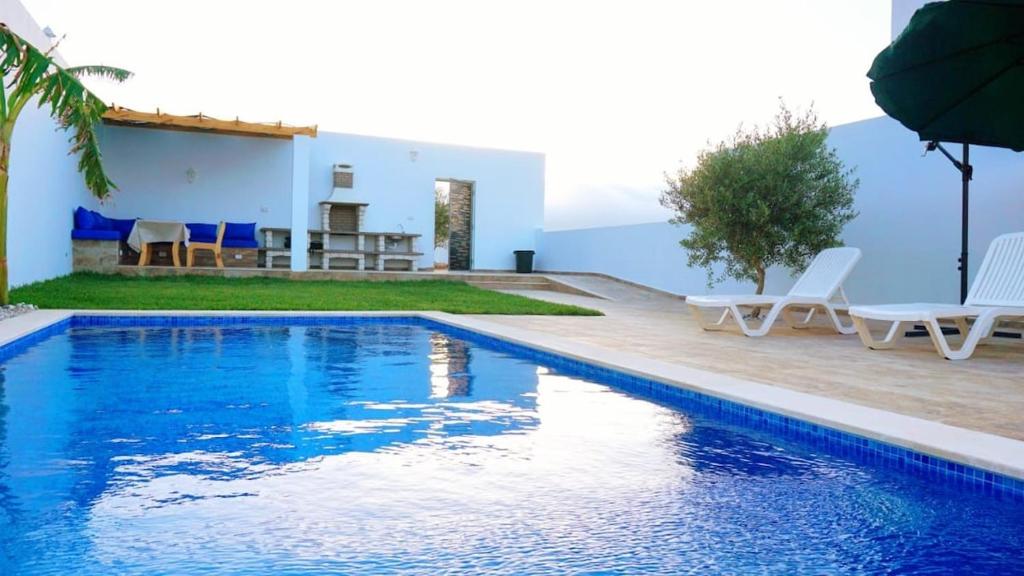 a swimming pool in front of a villa at Diar Jabal Villa S2 in Banī ‘Aţāʼ