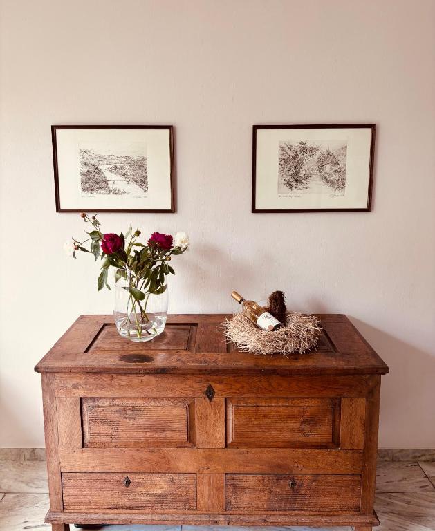 a vase of flowers on top of a wooden dresser at Gästehaus Am Rebenhang in Mehring