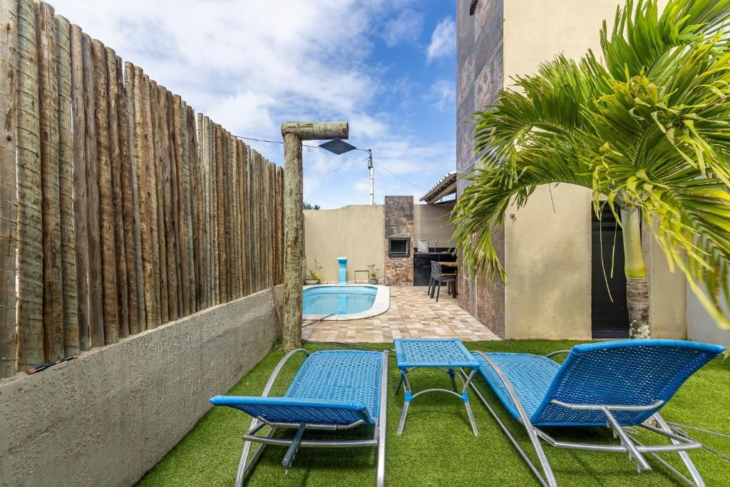 a yard with two chairs and a swimming pool at Casa inteligente com 4 suítes e piscina - 160D in Japaratinga