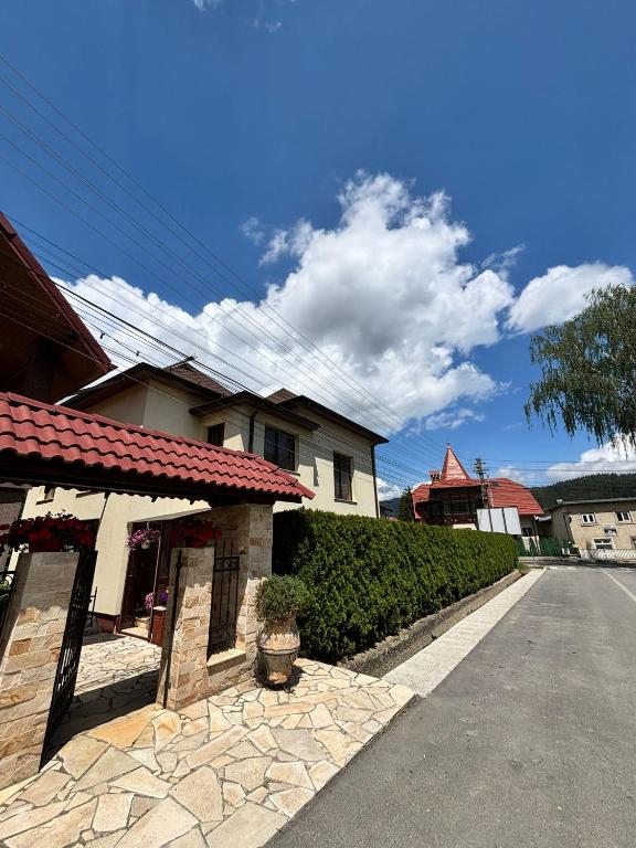 a house on a street next to a road at Casa in inima Bucovinei in Câmpulung Moldovenesc