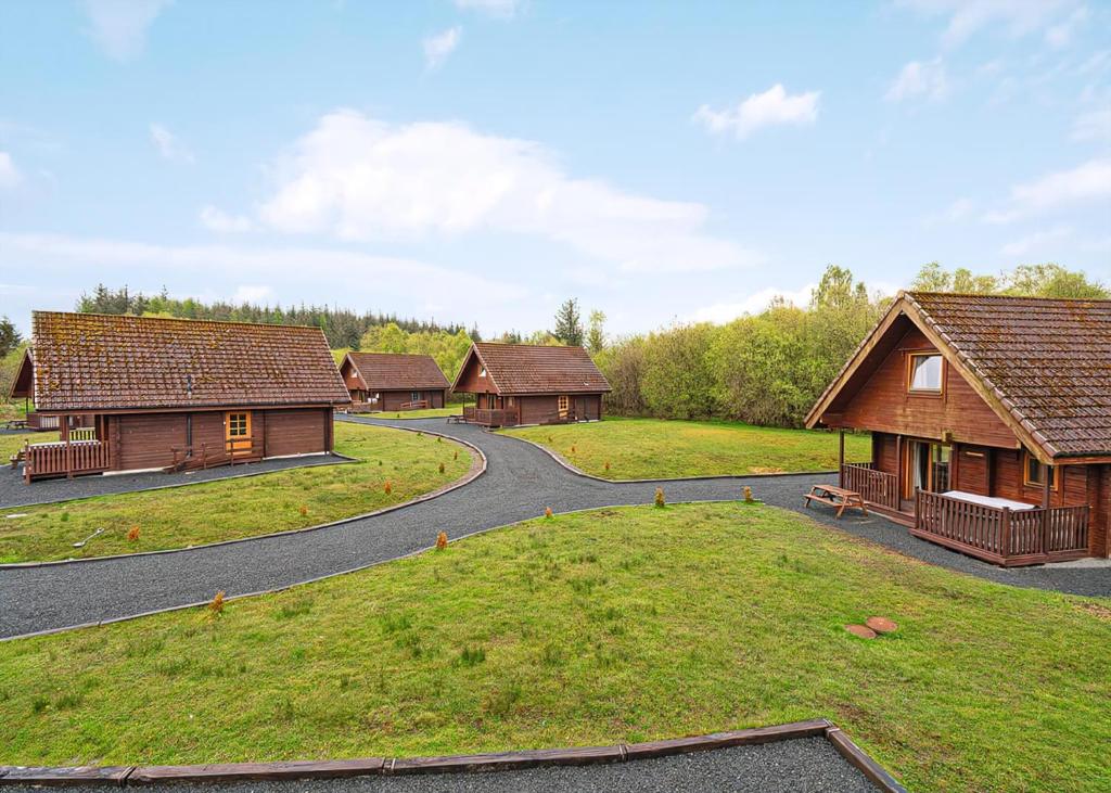 a winding road through a village with wooden buildings at Benview Holiday Lodges in Gartmore