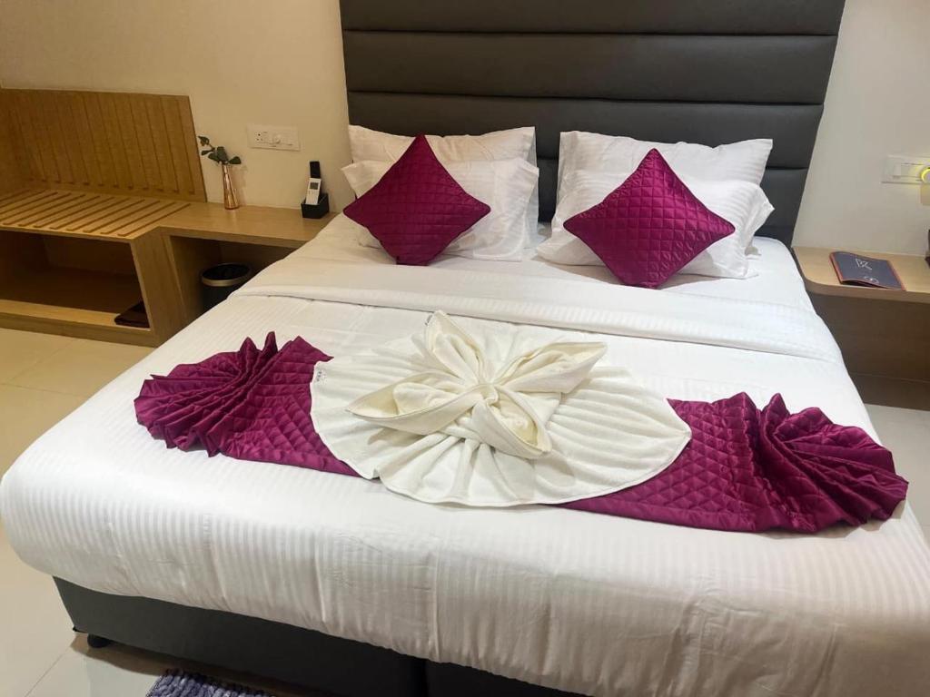 a bedroom with two beds with purple and white sheets at K Hotels by SYN in Bangalore
