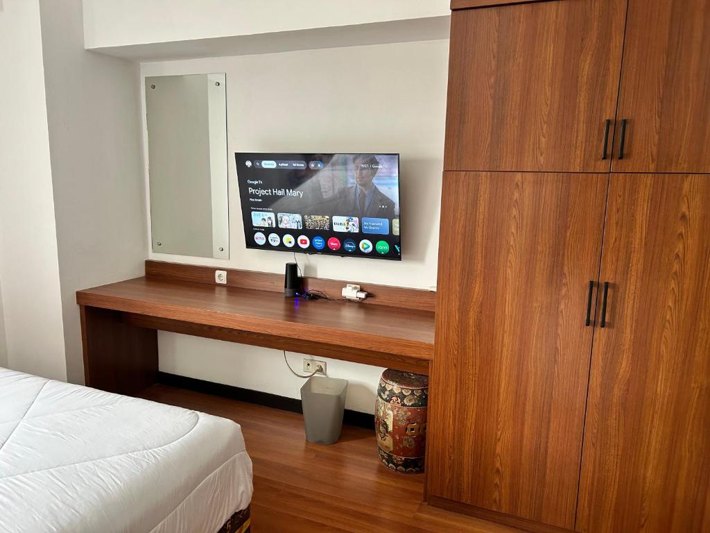 a bedroom with a wooden desk with a television on it at Apartment 3BR Prima Bragacitywalk in Bandung