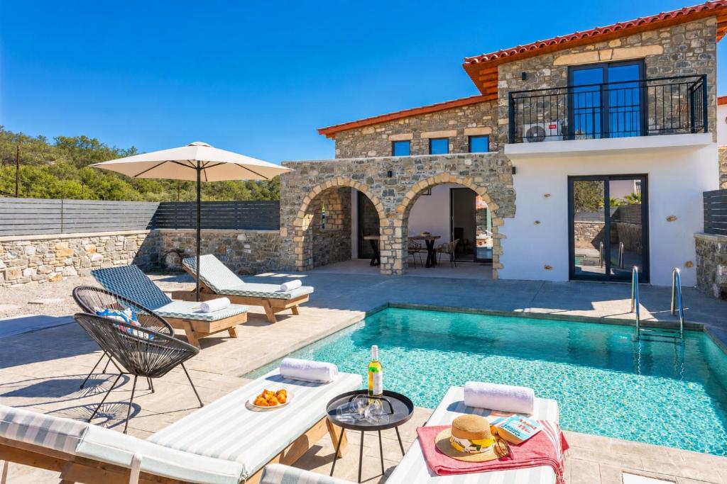 a villa with a swimming pool and a house at La Casa Di Pietre 1 in Kiotari