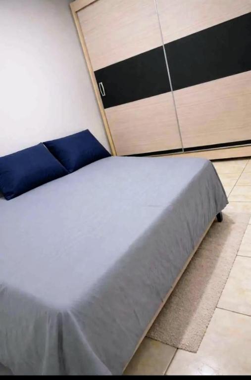 a bedroom with a large bed with blue sheets at Pensão por do sol in Ribeirão Preto