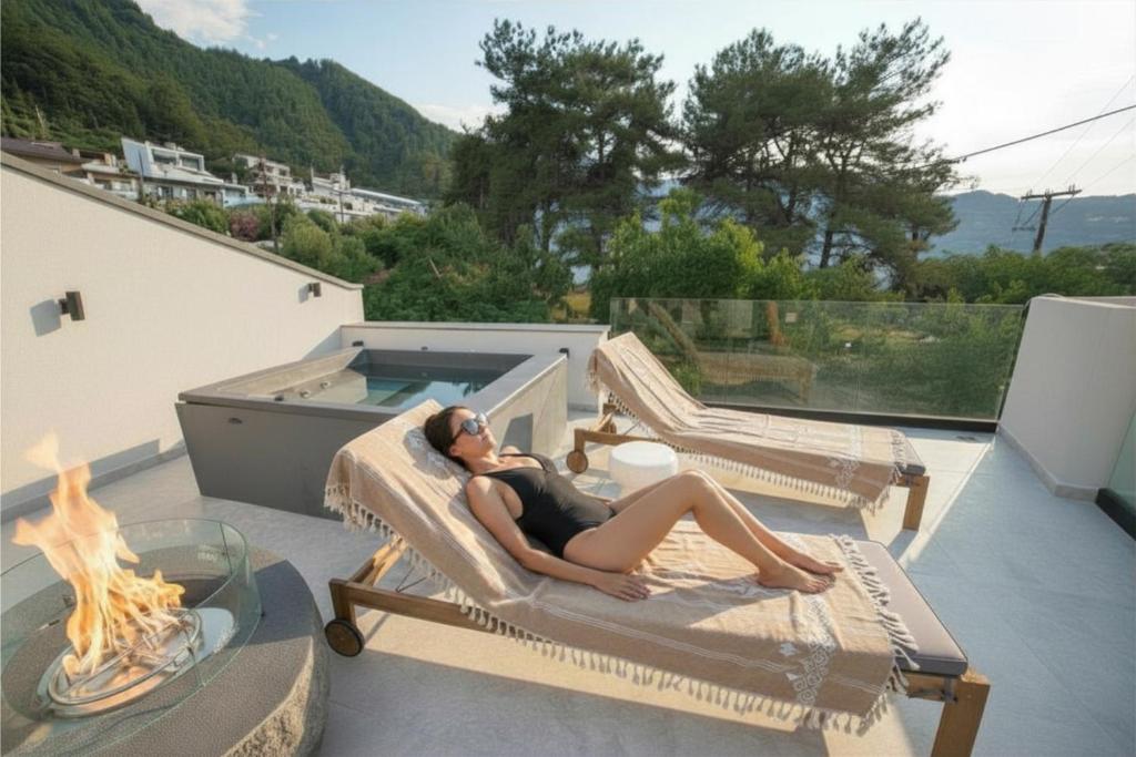 a woman laying on a chair next to a pool at ŌMNIMI Signature Living in Skala Potamias