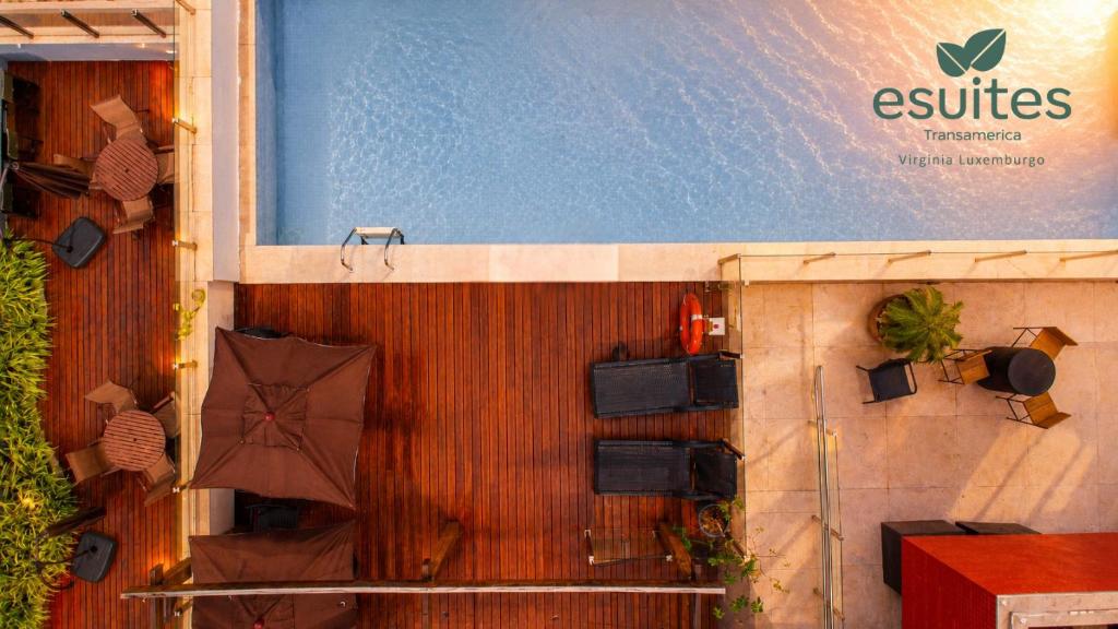 a wooden fence with chairs and an umbrella at Esuites Virgínia Luxemburgo in Belo Horizonte