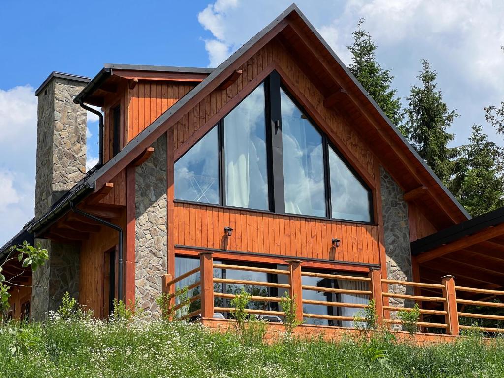 a house with large glass windows on the side of it at Chata Rosocha domek na wyłączność in Cisna