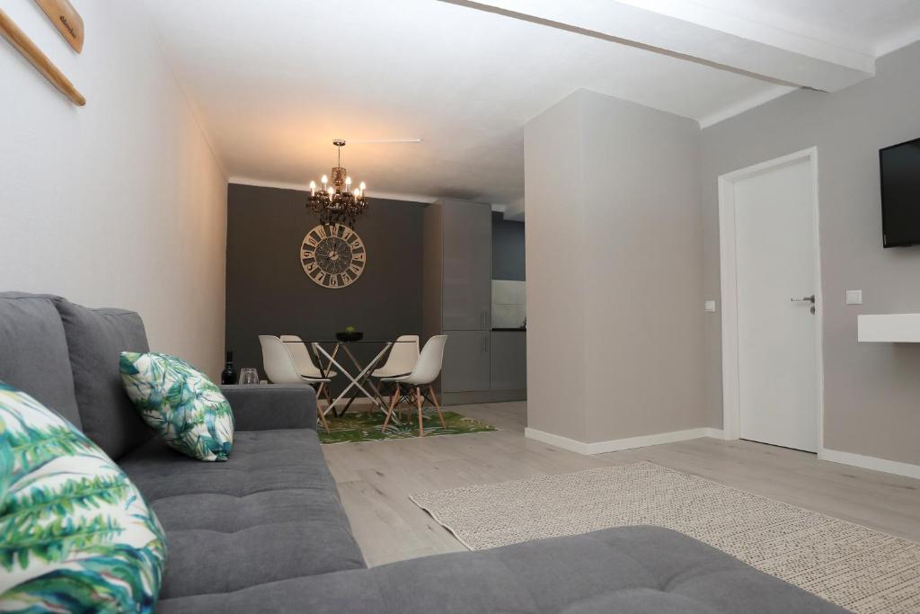 a living room with a gray couch and a table at Villa Bocage in Setúbal