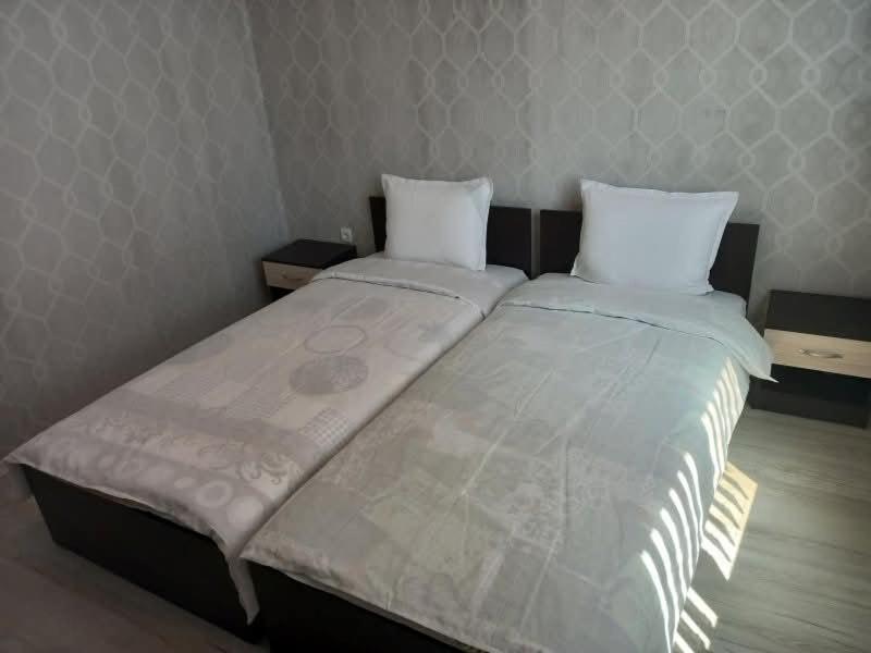 a bedroom with a large bed with two pillows at Къща за гости "Адам и Ева" in Kavarna