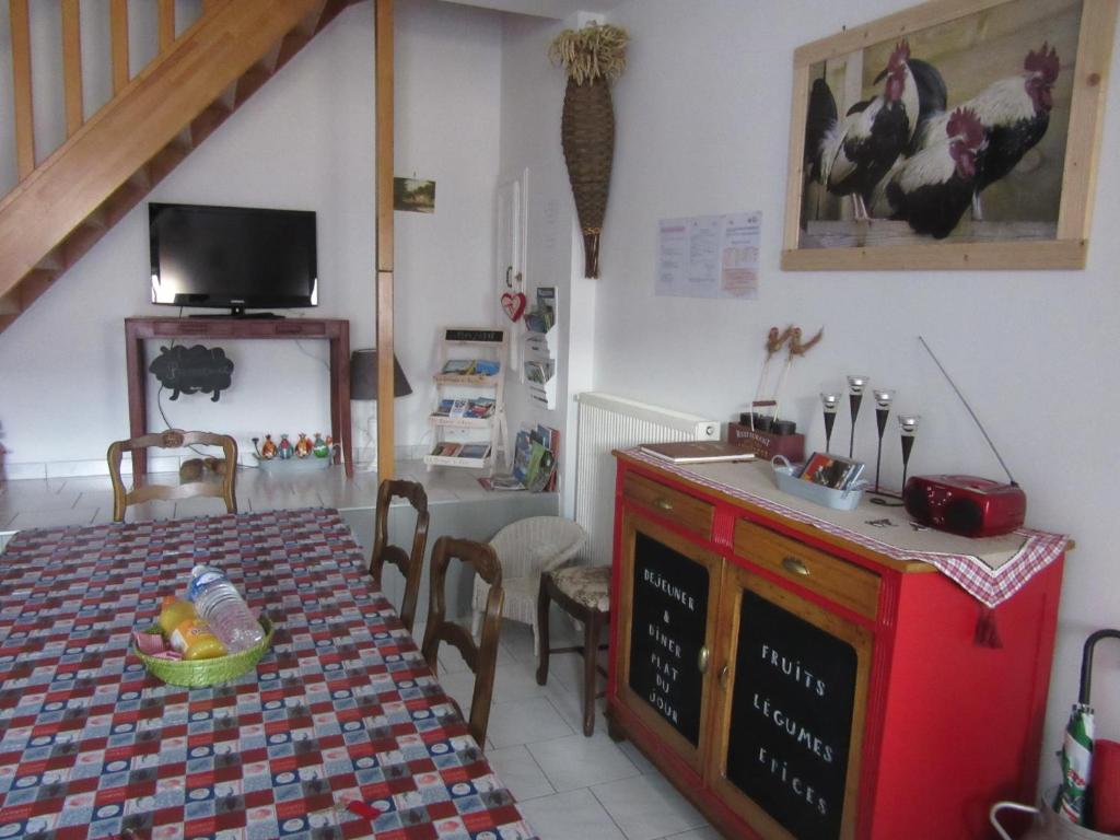 a dining room with a table and a tv at Gite La Grange à foin in Hannonville-sous-les-Côtes