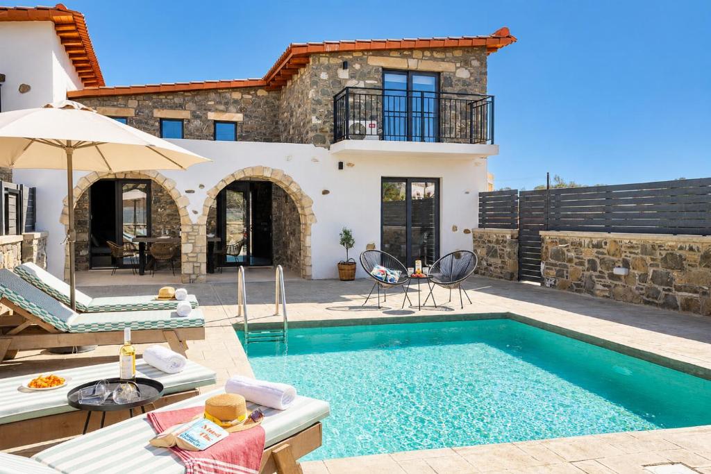 a villa with a swimming pool and a house at La Casa Di Pietre 3 in Kiotari