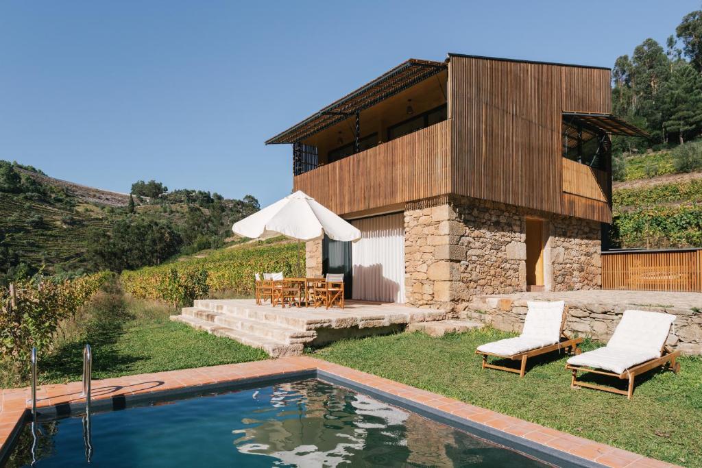 a house with a swimming pool in front of a building at Casa do Lagar by Quinta de Recião in Lamego