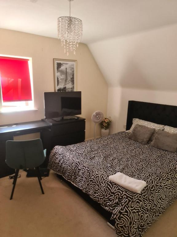 a bedroom with a bed and a desk and a television at Fv Dwelling in Hucknall