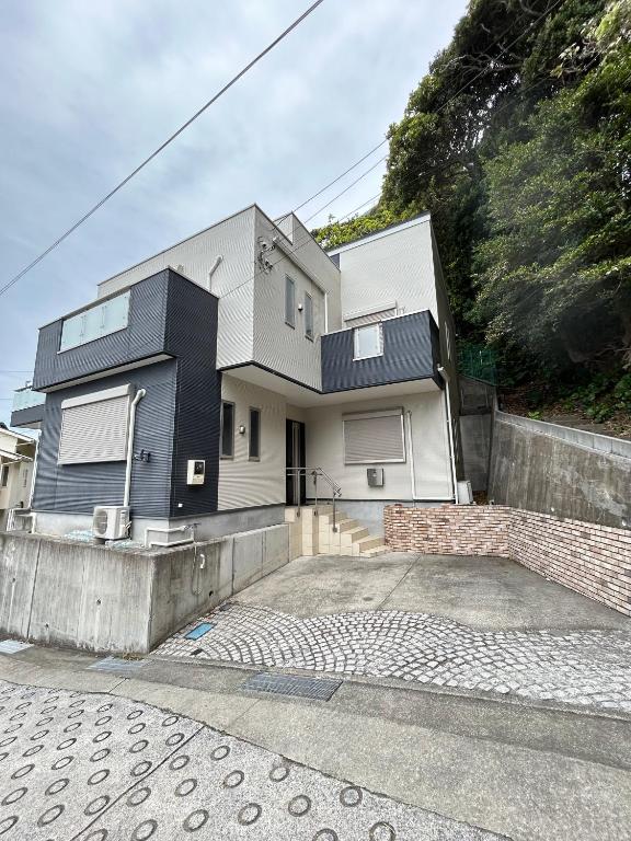 a house with a black and white facade at Outdoor Station 秋谷 in Yokosuka