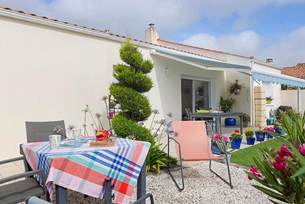 a table and chairs in the backyard of a house at Chambre D'hôtes Le Retour De Plage in Olonne-sur-Mer