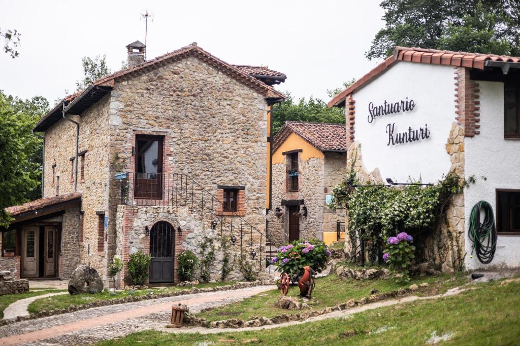 a stone house in a village with a street at Hotel Boutique Santuario Kunturi - Adults Only by Molino de Tresgrandas in Llanes