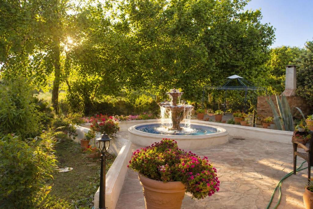 a fountain in the middle of a garden with flowers at Lesvos Garden Retreats - Mountain Voyage Residences in Vatoússa