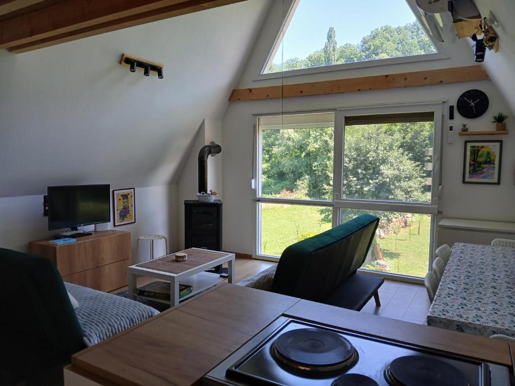 a living room with a table and a large window at Vila SVITAC Banja Vrujci in Mionica