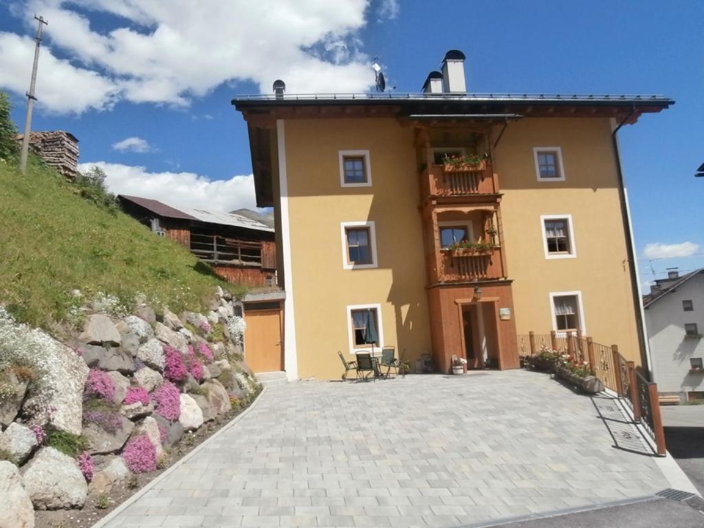 a large yellow building with a balcony on a hill at Cèsa Raggio di Sole in Arabba