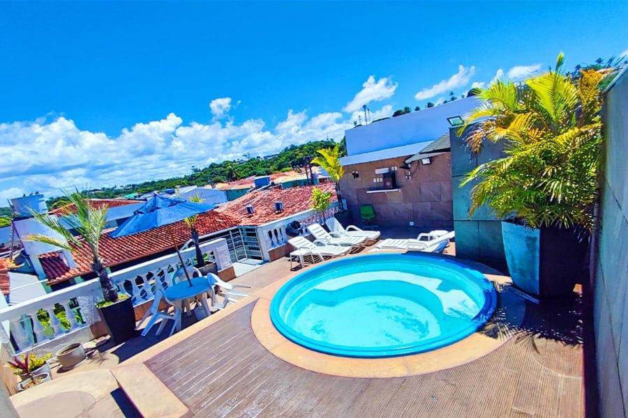 a large swimming pool on the deck of a house at Happy Hotel Ancoradouro in Porto Seguro