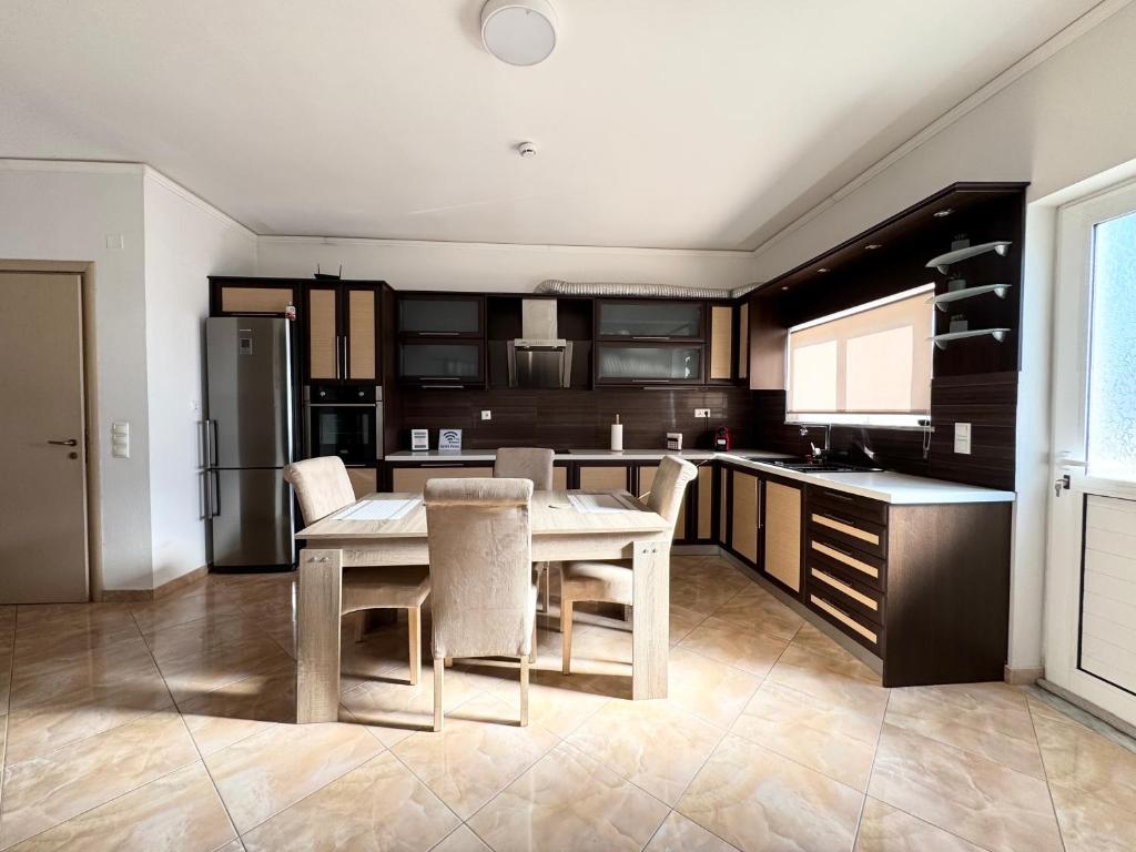 eine Küche mit Tisch, Stühlen und Kühlschrank in der Unterkunft Serenity house in Souda