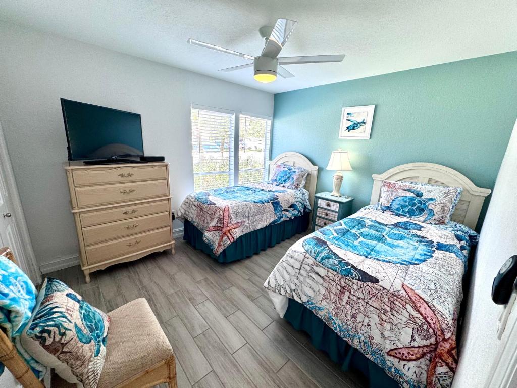 a bedroom with two beds and a tv and a dresser at 2BR/1BA Sienna Park, Sarasota Fl in Sarasota