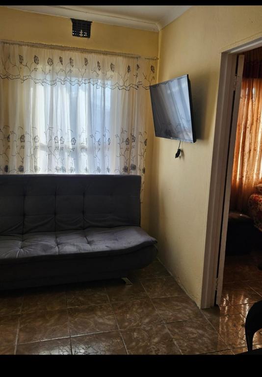 a couch sitting in a room with a window at Peace and Quiet accomodation in Richards Bay