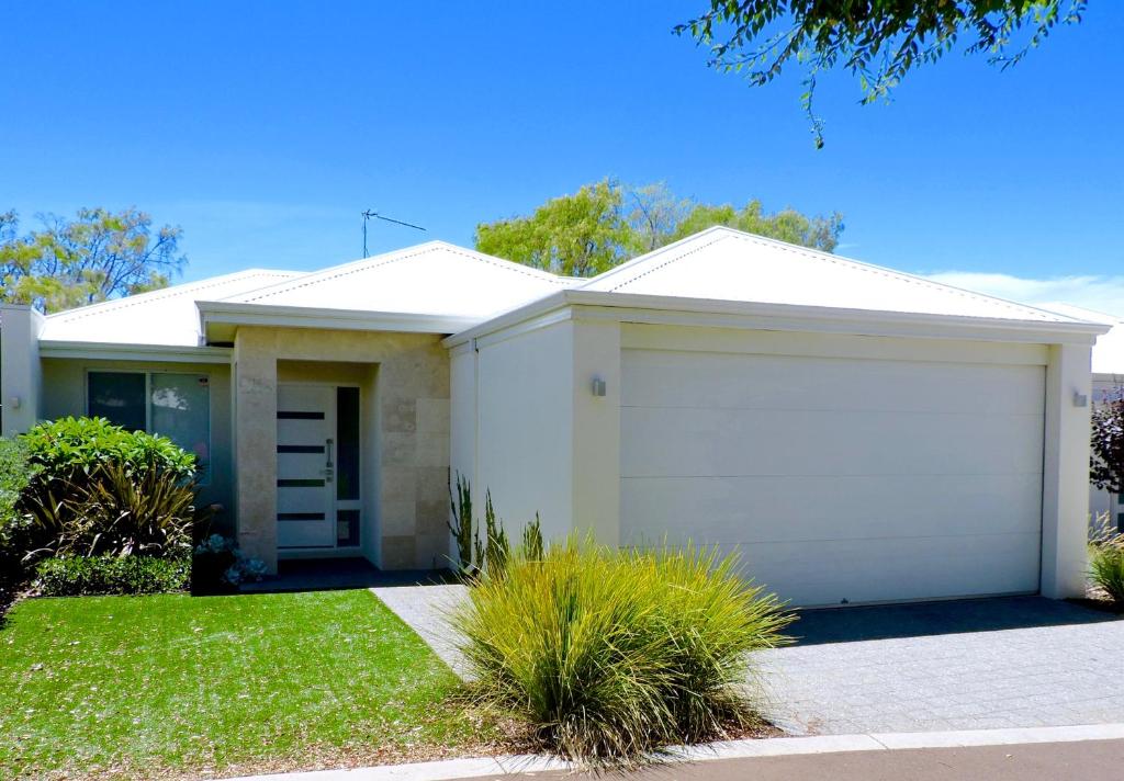 a white house with a garage at Contemporary Cove - Quindalup in Quindalup