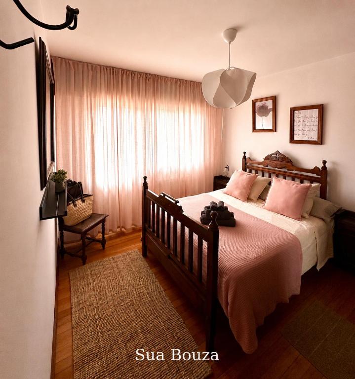 ein Schlafzimmer mit einem großen Bett und rosa Kissen in der Unterkunft Lar Do Lago - Rooms in Negreira