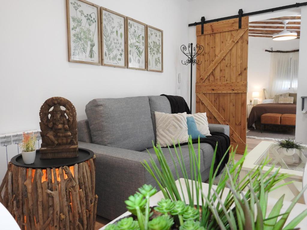 a living room with a gray couch and a wooden table at Casa Rural Isabel y Luis in Chiloeches
