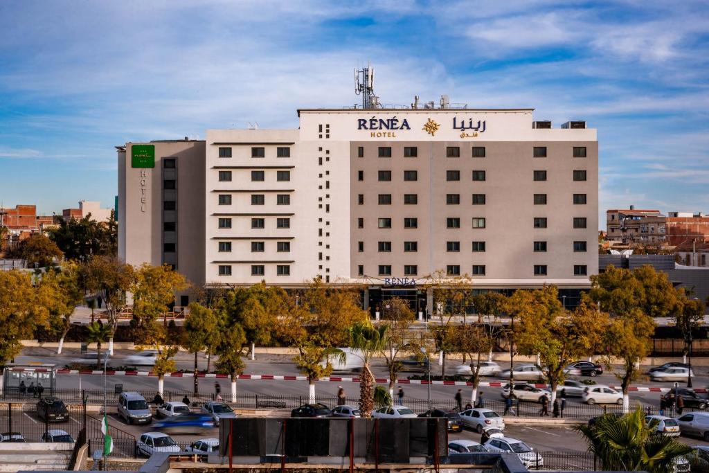 a large white building with a sign on it at Rénéa Hotel in Sétif