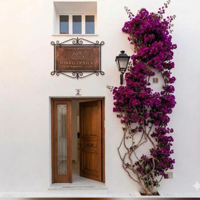 a building with a sign and purple flowers on it at Marbella Views in Ojén