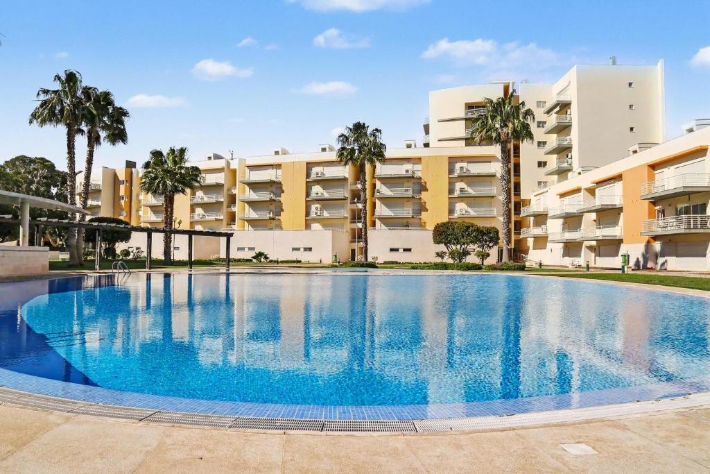 a large swimming pool in front of a building at Brisa Do Mar Moura Beach in Quarteira