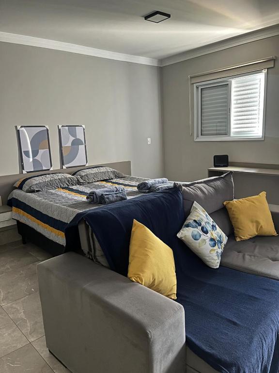 a bedroom with a large bed and a couch at Seu espaço in Sorocaba