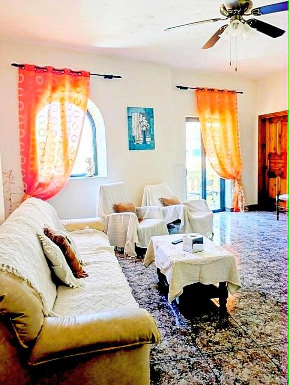 a living room with a couch and tables in it at Silia's Maisonette in Marsaskala