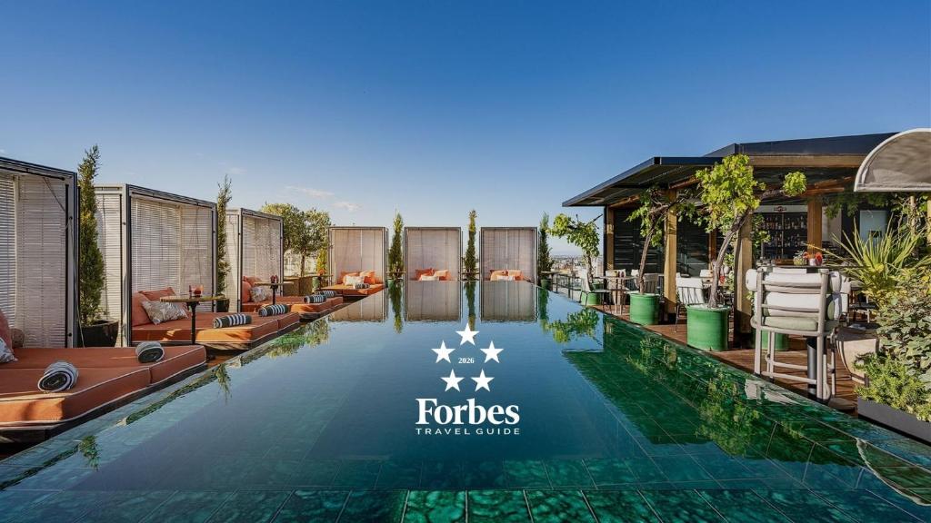 a pool at a hotel with chairs and tables at BLESS Madrid - The Leading Hotels of the World in Madrid