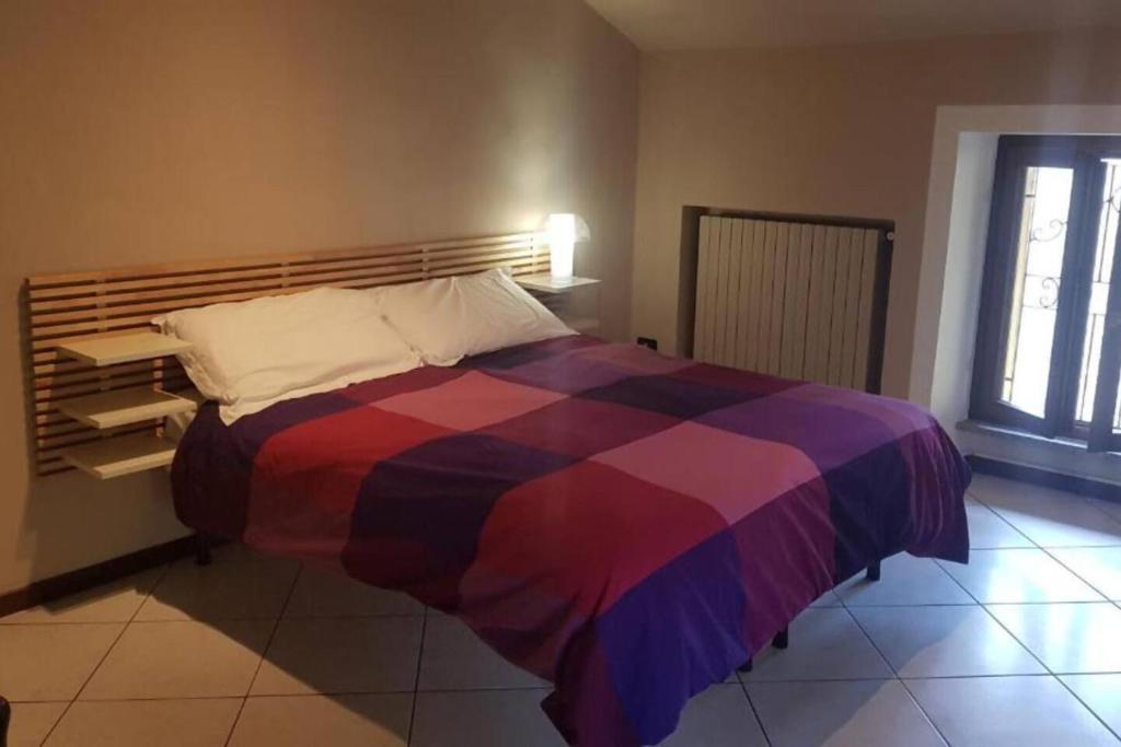 a bed in a room with a colorful blanket at Ca di Biella, mansarda di charme. in Biella
