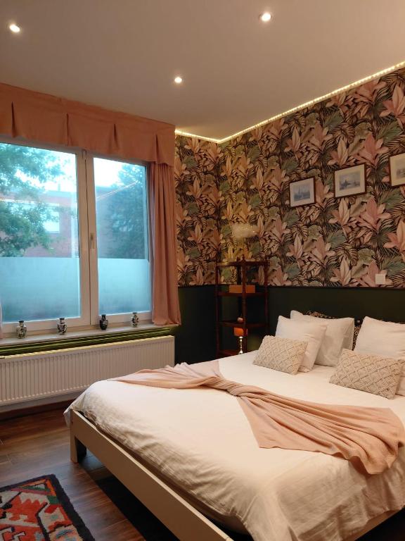 a bedroom with two beds and a large window at B&B Fleur in Schoten
