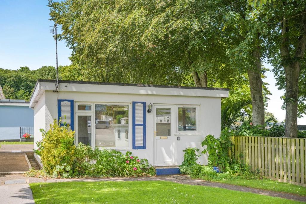 a small white shed with blue trim in a yard at 2 Bed in Brixham oc-bx081 in Brixham
