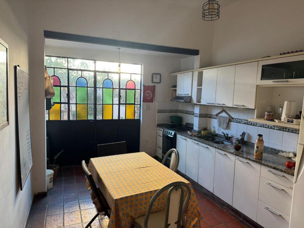 eine Küche mit einem Tisch und einem Buntglasfenster in der Unterkunft CASA Mito in Río Cuarto