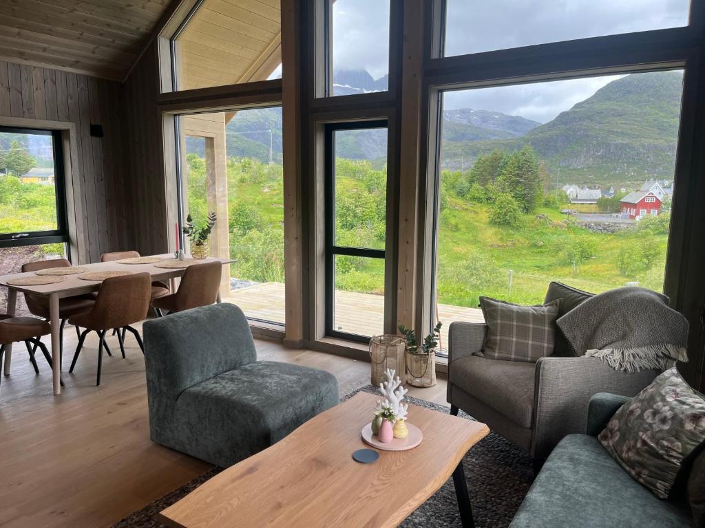a living room with a couch and chairs and a table at Lofoten Arctic Cabin in Sørvågen
