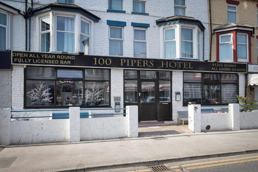 a building with a hotel on the corner of a street at 100 Pipers Hotel in Blackpool
