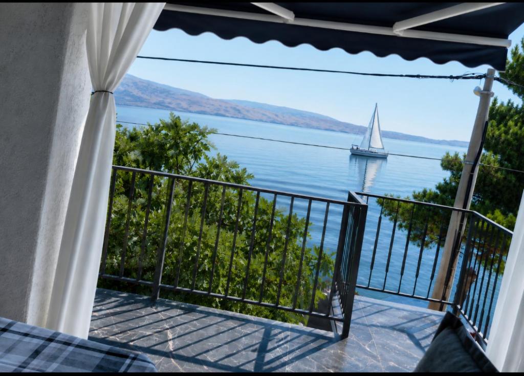 a view of a sailboat on the water from a balcony at Romantic Apartment Sonja, Beachfront in Cesarica