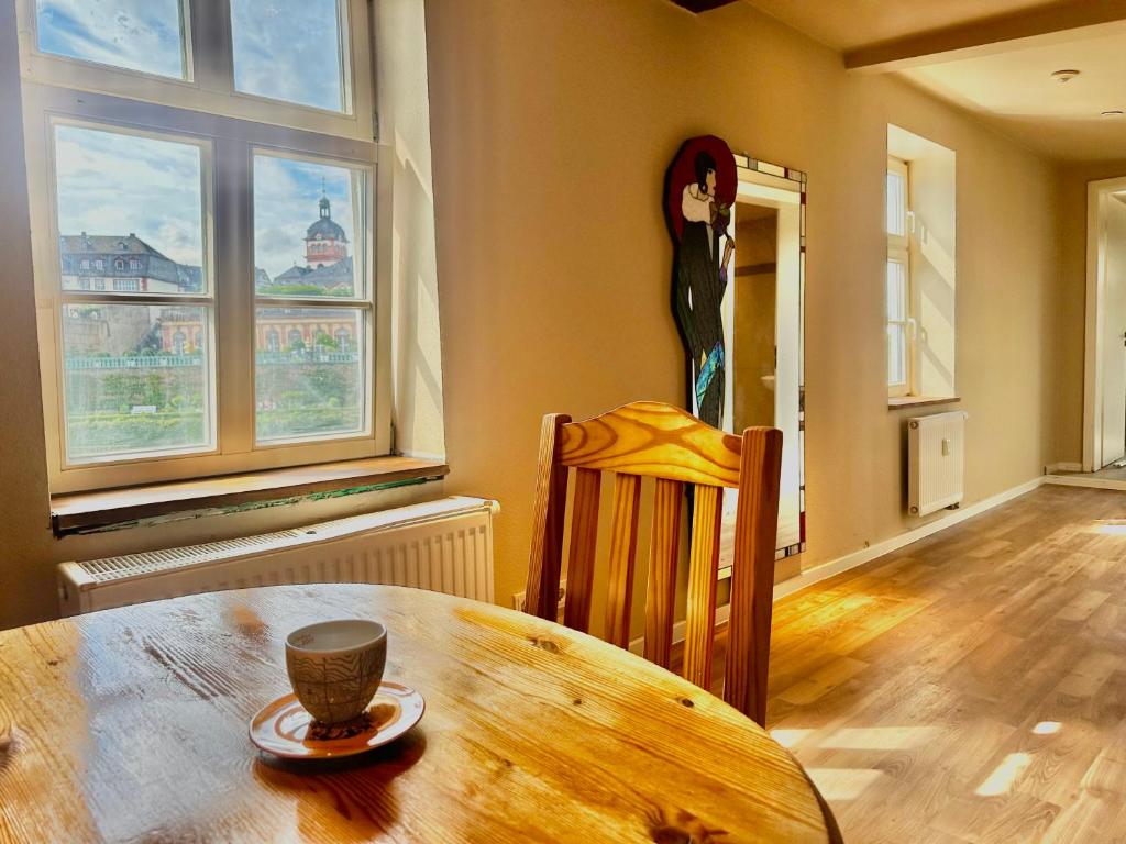 a dining room with a wooden table with a cup on it at Apartment Weilburg Lahnblick in Weilburg
