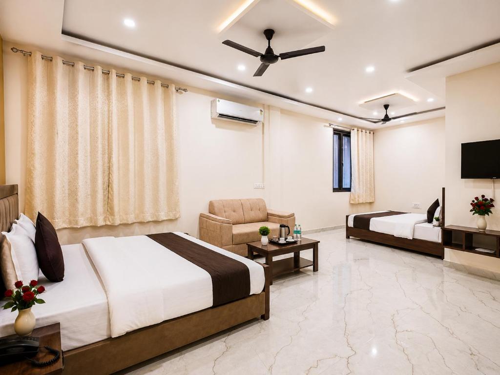 a hotel room with two beds and a television at Kanha Green in Habībganj